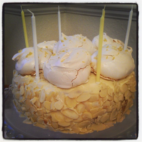 A lemon birthday cake with meringue decoration and candles